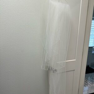 Includes long veil. Slight discoloring on lace at bottom of the dress.